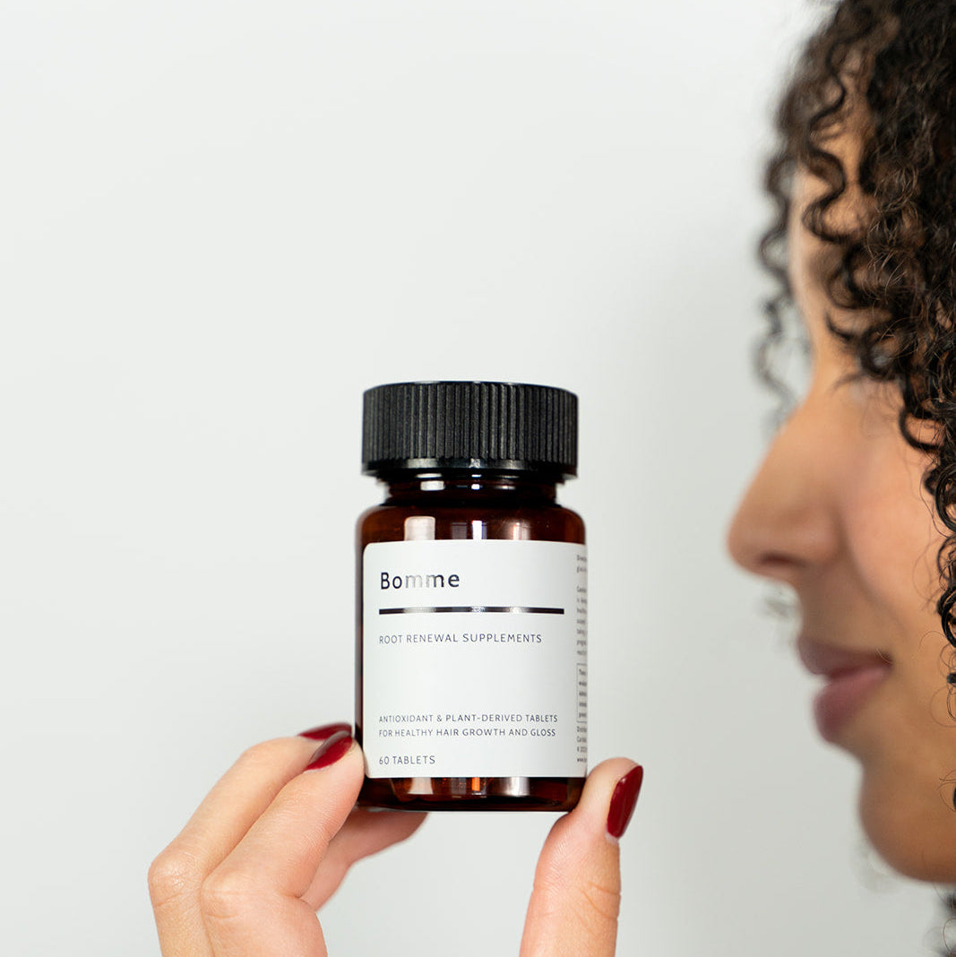 Person holding a bottle labeled &