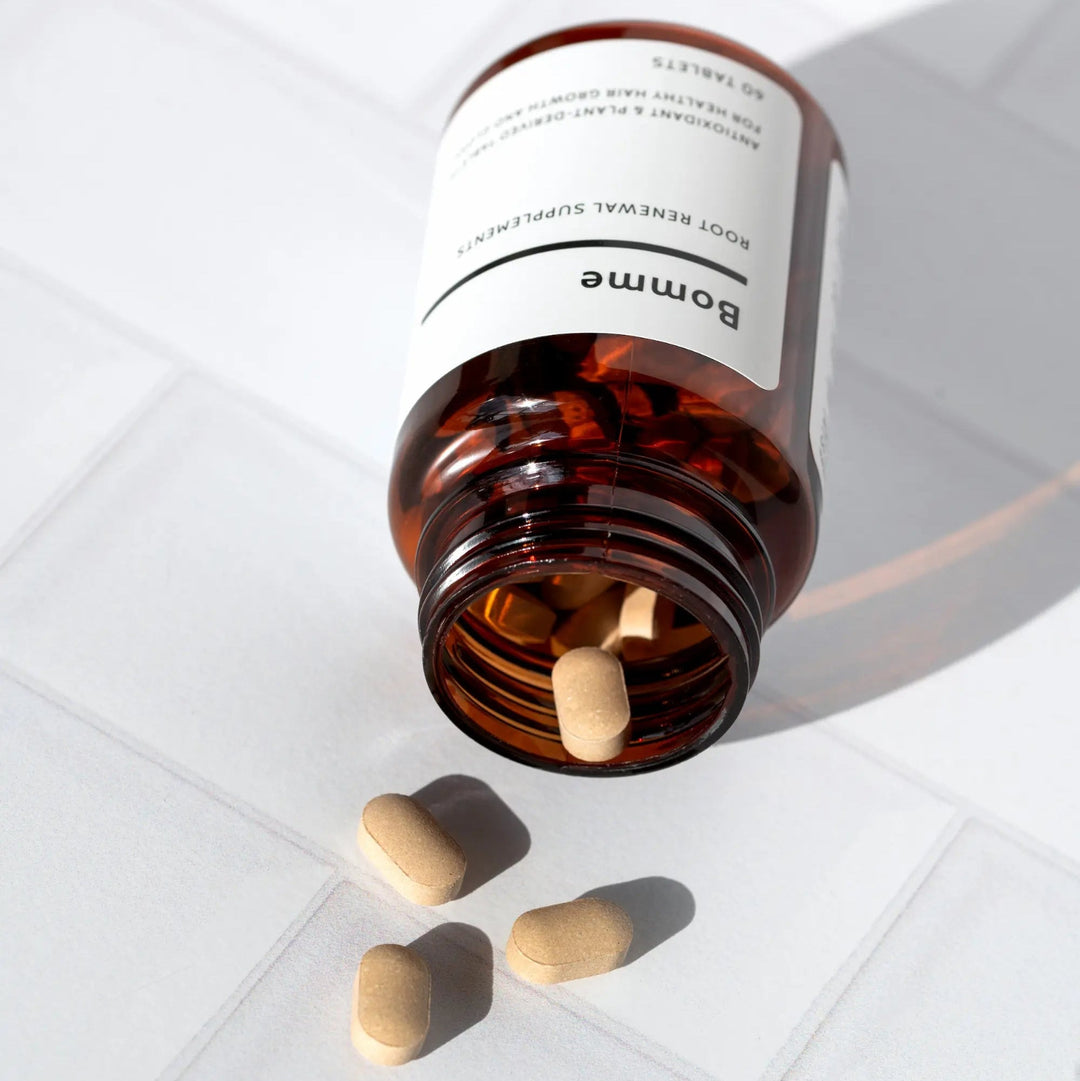 Bomme Supplements with Brown glass bottle and pills on a white surface