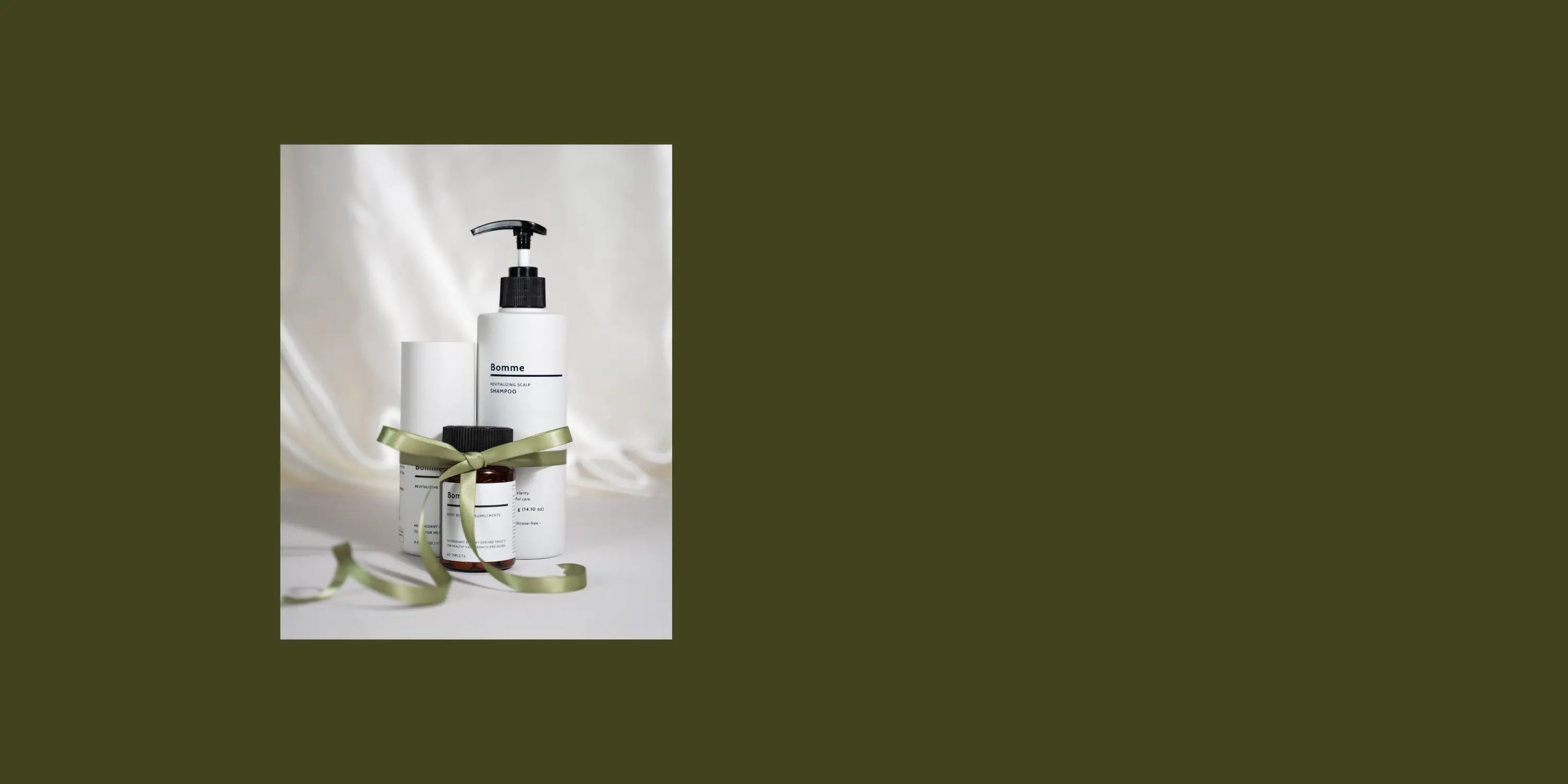 Bomme haircare products with a green ribbon on a white background