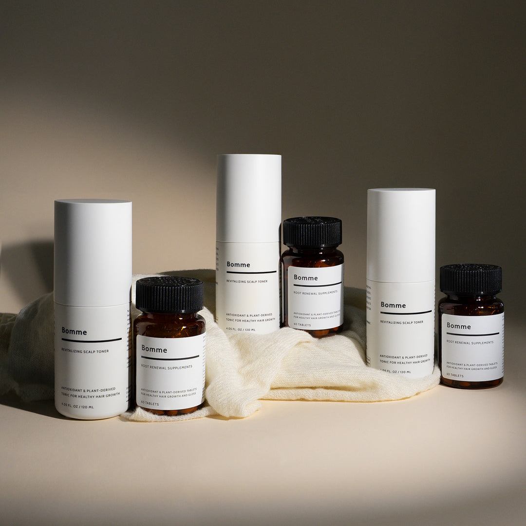 Bomme Essentials Set featuring a three-month supply of Revitalizing Scalp Toner and Root Renewal Supplements, displayed with minimalist packaging on soft fabric.
