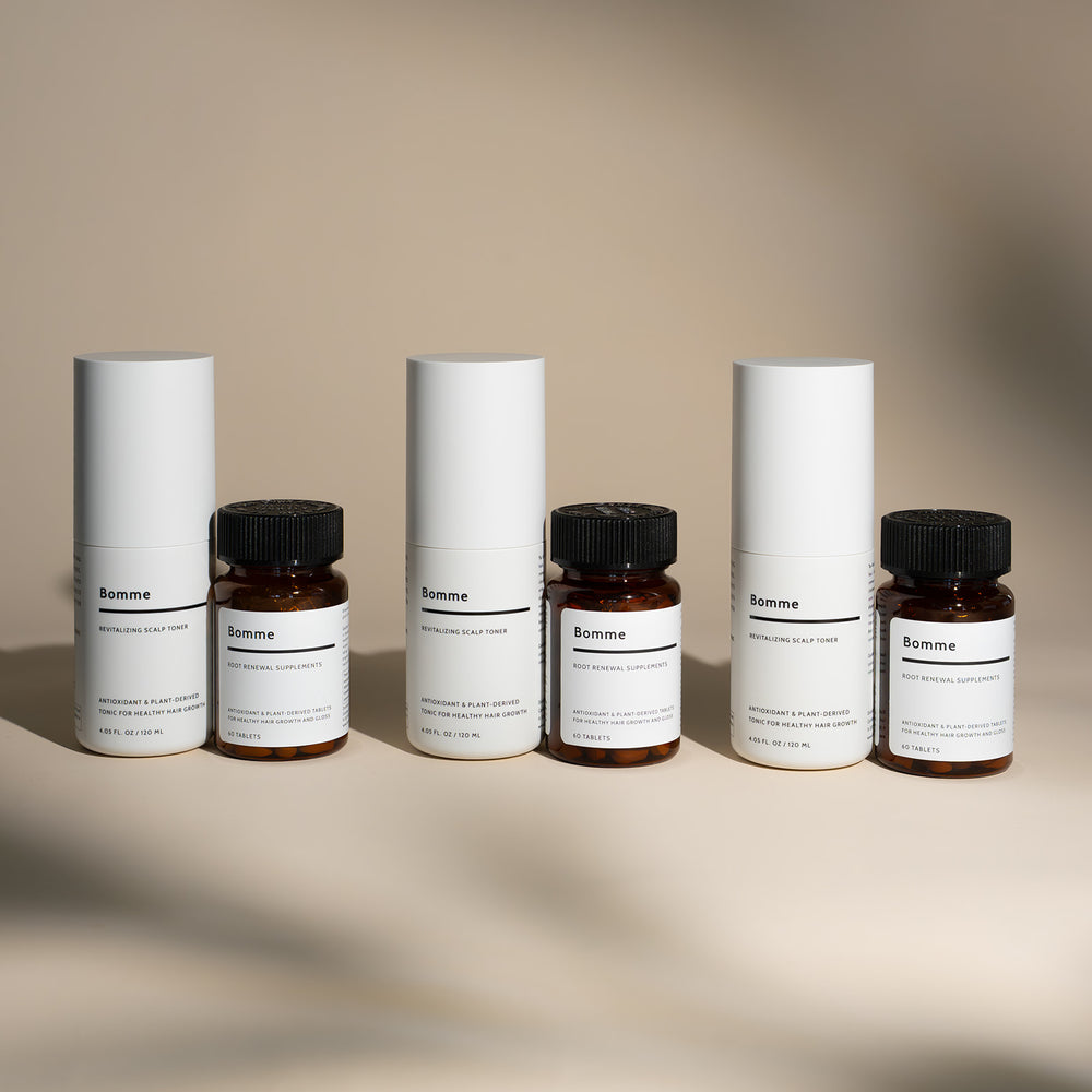 Bomme Essentials Set displayed with a three-month supply of Revitalizing Scalp Toner and Root Renewal Supplements, minimalist white and amber packaging on neutral background.