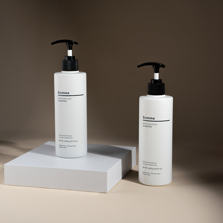Two bottles of Bomme Revitalizing Scalp Shampoo with minimalist packaging, displayed on neutral background.