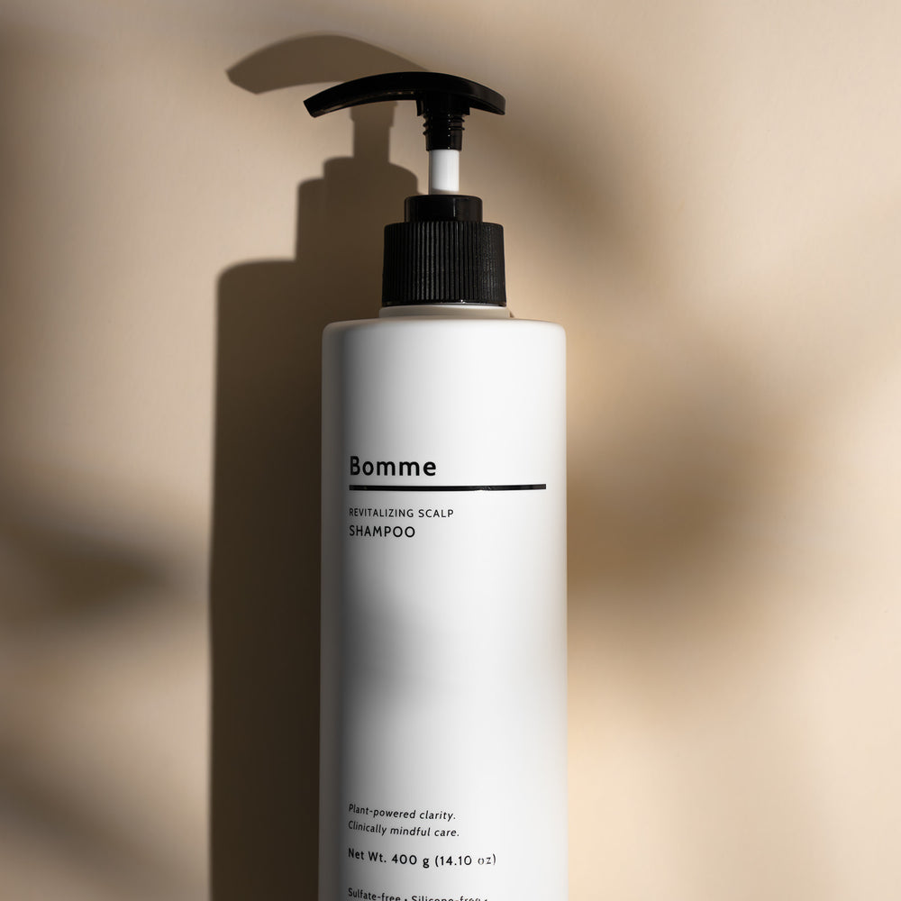 Bomme Revitalizing Scalp Shampoo bottle with sleek white packaging, sulfate-free and plant-powered formula.